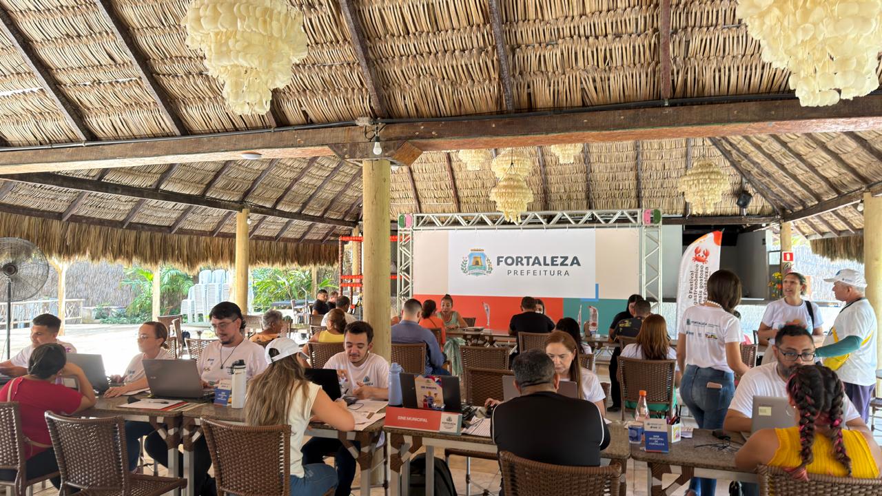 pessoas sentadas em frente a mesas com computador